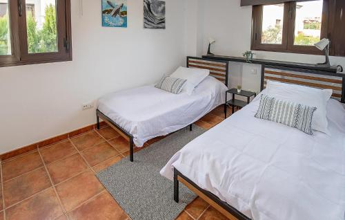two beds in a room with two windows at Nice Home In Guillena With Wifi in Guillena