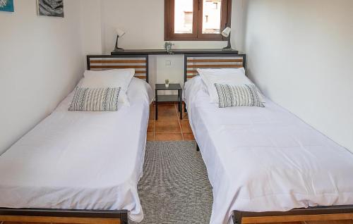 two twin beds in a room with a window at Nice Home In Guillena With Wifi in Guillena