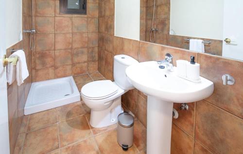 a bathroom with a white toilet and a sink at Nice Home In Guillena With Wifi in Guillena