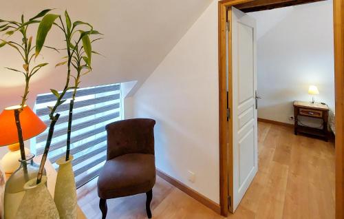 a room with a chair and a table with a lamp at 2 Bedroom Cozy Home In Plumieux in Plumieux