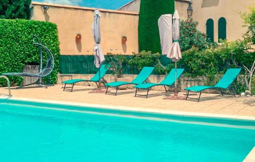 un groupe de chaises et de parasols à côté d'une piscine dans l'établissement Lovely Home In Malemort-Du-Comtat, à Malemort-du-Comtat