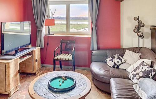 un salon avec un canapé et une télévision dans l'établissement Stunning Home In Cricqueville En Bessin, à Cricqueville-en-Bessin