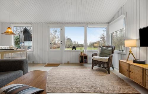 a living room with a couch and a chair and windows at Nice Home In Kalundborg With Wifi in Kalundborg