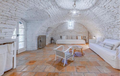 Cette chambre blanche comprend un lit, un canapé et une table. dans l'établissement Amazing Home In Le Rouet With Wifi, à Notre-Dame-de-Londres