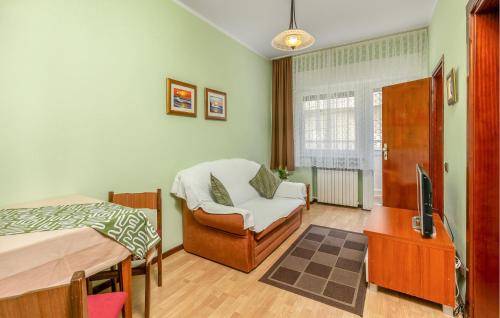 une chambre avec un lit, une télévision et une chaise dans l'établissement Nice Apartment In Palit With Wifi, à Palit