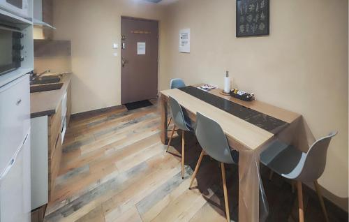 une cuisine avec une table et des chaises dans une pièce dans l'établissement Cozy Apartment In Saint Chinian, à Saint-Chinian