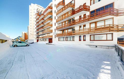un parking couvert de neige en face d'un bâtiment dans l'établissement 2 Bedroom Nice Apartment In La Mongie, à La Mongie