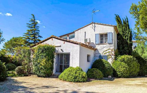 une maison blanche avec des buissons devant elle dans l'établissement Nice Home In Lisle-Sur-La-Sorgue, à LʼIsle-sur-la-Sorgue