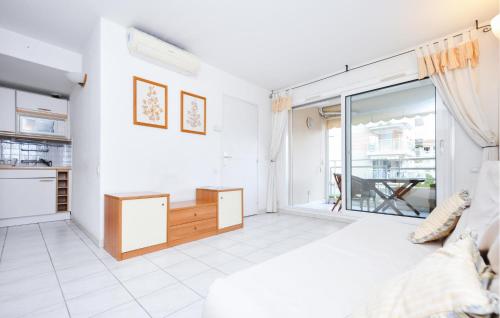 Cette chambre blanche dispose d'un lit et d'une grande fenêtre. dans l'établissement Cozy Apartment In Vallauris With Wifi, à Vallauris