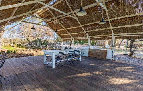 un patio avec une table et des chaises sous un toit dans l'établissement Cozy Home In Le Rouet With Wifi, à Notre-Dame-de-Londres