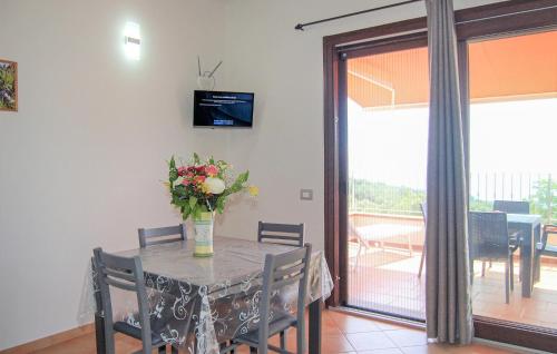 ein Esszimmer mit einem Tisch mit einer Vase mit Blumen in der Unterkunft Nice Apartment In San Giovanni A Piro in San Giovanni a Piro