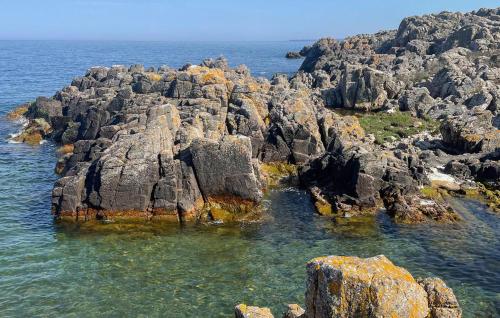 a group of rocks in the water near the ocean at Gudhjem Søpark Lejl 47 in Gudhjem