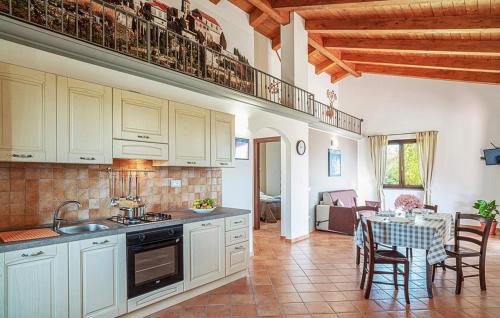 a kitchen with white cabinets and a dining room with a table at Lovely Home In San Giovanni A Piro in San Giovanni a Piro