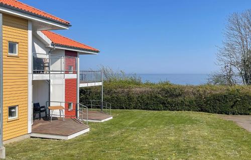 a house with a balcony with a view of the ocean at Gudhjem Søpark Lejl 47 in Gudhjem