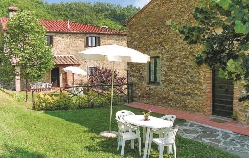 a table and chairs with an umbrella in a yard at Gorgeous Home In Dicomano With Wifi in Dicomano