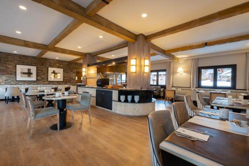 a restaurant with wooden ceilings and tables and chairs at Eurostars Royal Tanau in Baqueira-Beret