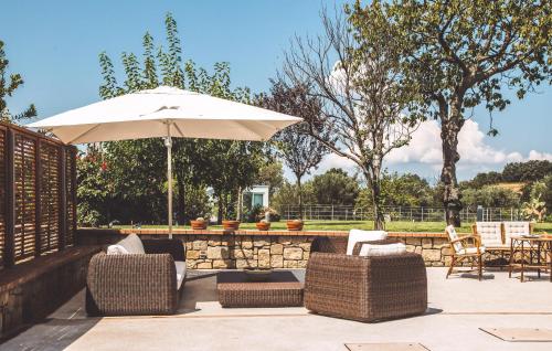 a patio with chairs and an umbrella and a table at Amazing Home In Vallo Della Lucania in Vallo della Lucania