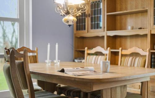 a dining room table with chairs and a chandelier at 2 Bedroom Beautiful Home In Hovborg in Hovborg