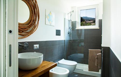 a bathroom with a sink and a toilet and a mirror at Amazing Home In Vallo Della Lucania in Vallo della Lucania
