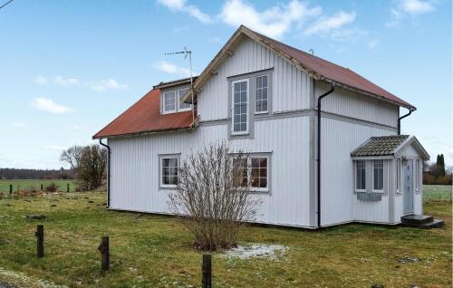 a white house with a red roof in a field at 4 Bedroom Pet Friendly Home In Upplid in Upplid