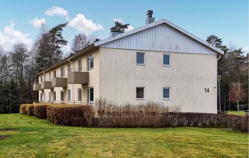 a large white building with a grass field in front of it at 2 Bedroom Stunning Apartment In Grimsås in Grimsås