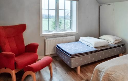 a bedroom with a bed and a chair and a window at 4 Bedroom Pet Friendly Home In Upplid in Upplid