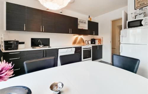 a kitchen with black cabinets and a white refrigerator at 2 Bedroom Stunning Apartment In Grimsås in Grimsås
