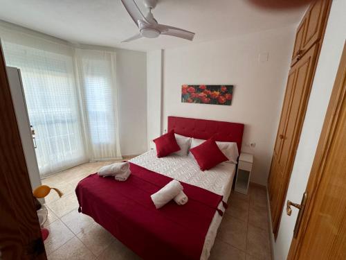 a bedroom with a red bed with red pillows at Acogedor apartamento en el grau de Moncofa con wifi in Moncófar