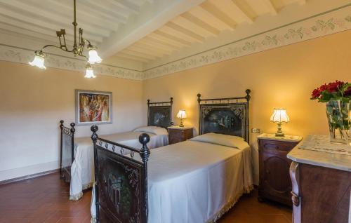 a bedroom with two beds and a table with flowers at Luxurious Home In Monterchi in Monterchi