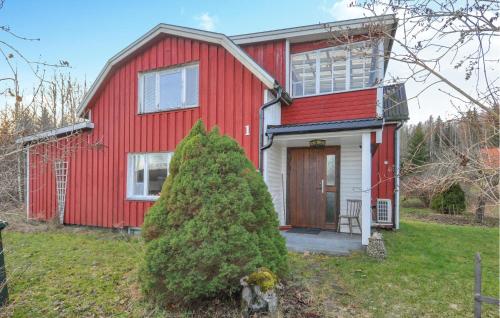 a red house with a christmas tree in front of it at Lovely Home In Fengersfors With Wifi in Fengersfors