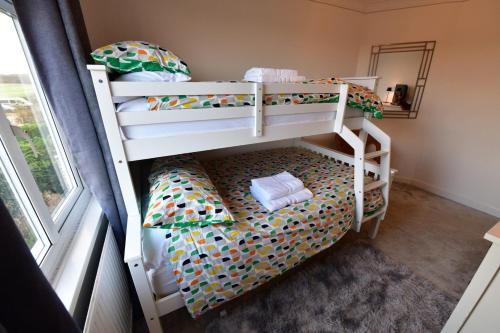 two bunk beds in a room with a window at 2BD Garden Home - A Short Walk to Stonehenge in Lark Hill