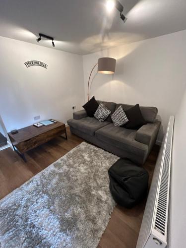 a living room with a couch and a table at Hill Street Railway retreat. in Elsecar