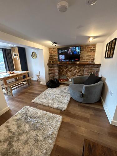 a living room with a couch and a fireplace at Hill Street Railway retreat. in Elsecar