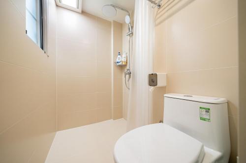 a white bathroom with a toilet and a shower at Tonight Homestay Jing'an Temple Branch Shanghai in Shanghai