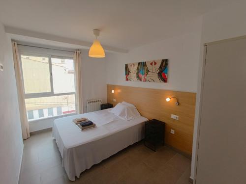a bedroom with a white bed and a window at Apartamentos Marina Suites in Grao de Castellón