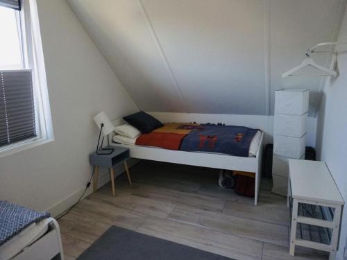 a small bedroom with a bed in a attic at Beautiful Villa close to beaches in Sint Maarten