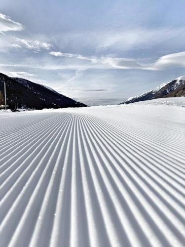 a field covered in snow with mountains in the background at Nanisgarten - Grannys flat in Obergesteln