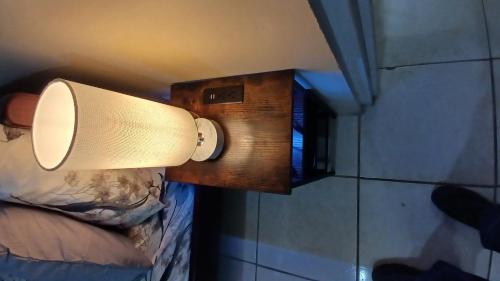 a light on the wall of a room with a bed at Cozy Vacation Retreat Apt 2 in Trafalgar