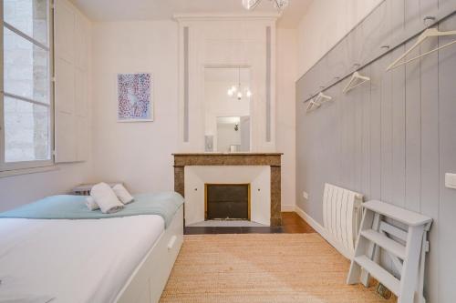 une chambre avec un lit et une cheminée dans l'établissement MDOR Le Nid Bleu - Au coeur de Bordeaux, à Bordeaux