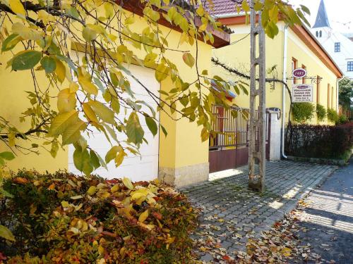 a yellow building with a pole next to a street at Angéla Vendegház in Tokaj