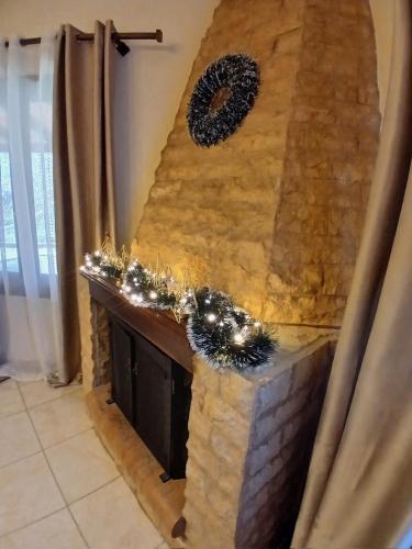 a stone fireplace with christmas wreaths on it at Μονοκατοικία μέσα στα έλατα in Lávka