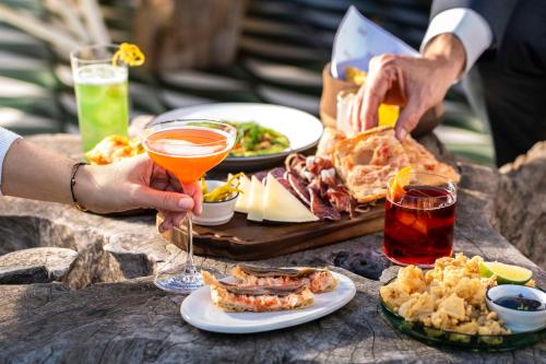 a table topped with plates of food and drinks at Radisson Blu 1882 Hotel, Barcelona Sagrada Familia in Barcelona