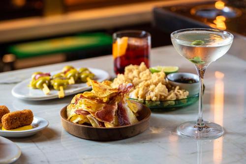a table with a plate of food and a glass of wine at Radisson Blu 1882 Hotel, Barcelona Sagrada Familia in Barcelona