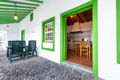 a room with green doors and a table and chairs at Casa de Los Establos - Finca Camacho in Santa Cruz de la Palma