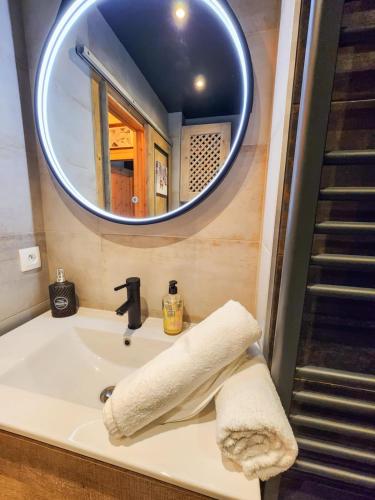 une salle de bain avec un lavabo et un miroir dans l'établissement L'Ecrin de Megève, à Megève