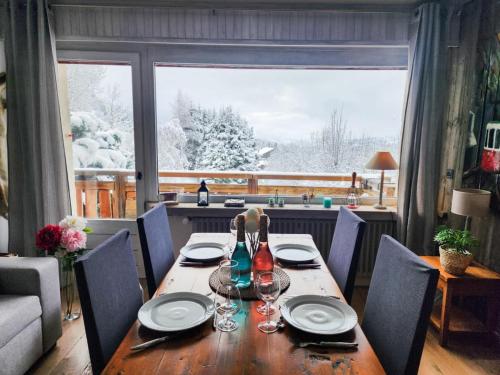 - une table à manger avec des assiettes et des verres à vin dans l'établissement L'Ecrin de Megève, à Megève