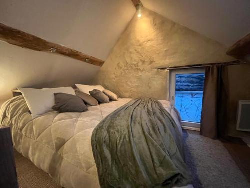 une chambre avec un grand lit avec une fenêtre dans l'établissement La Petite Maison, à Survilliers