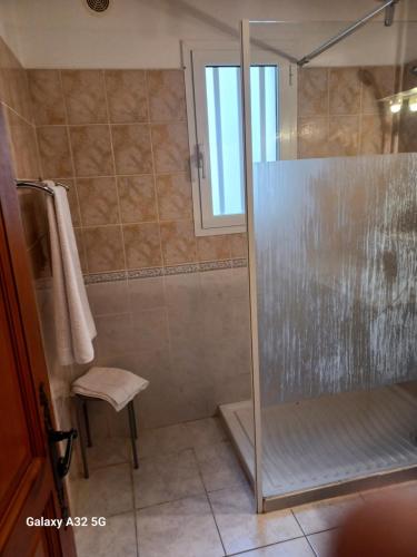 une salle de bain avec une douche avec une porte vitrée dans l'établissement Residence les Lavandes, à Olmeto