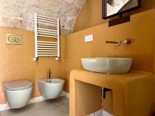 a bathroom with a sink and a toilet at Terre Saracene Suites in Bitonto