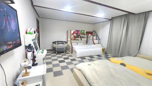 a small room with two beds and a tv at Kids & Family Hotel in Gyeongju
